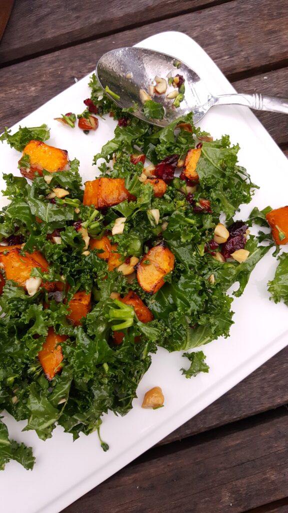 kale broccolini sweet potato salad on white plate with spoon