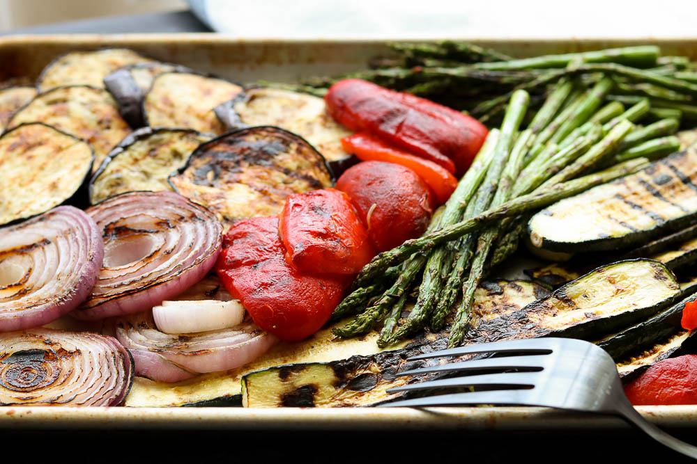 horizontal view of grilled balsamic vegetables on sheet pan with serving fork 