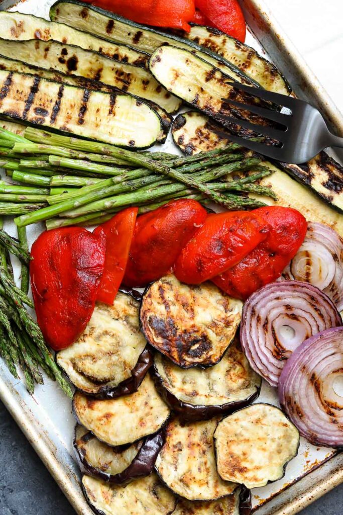 grilled balsamic vegetables on sheet pan with serving fork 