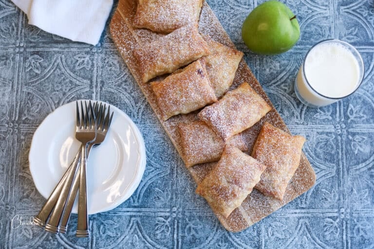 easy apple pie puffs on serving board with plates and milk