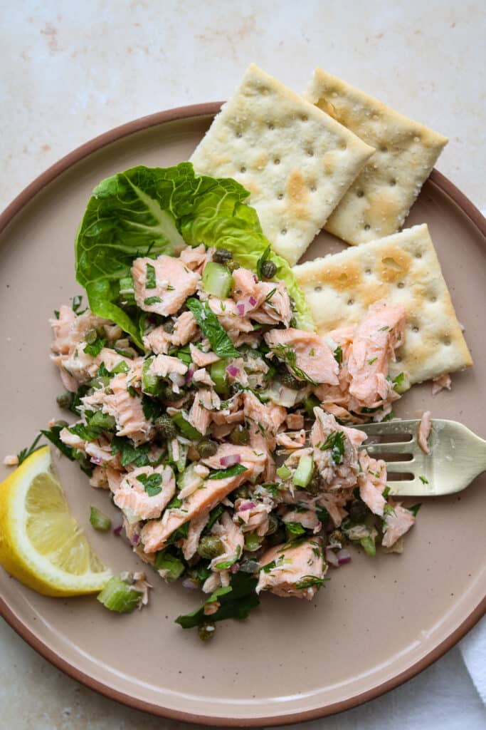 chilled poached salmon salad on plate with crackers 