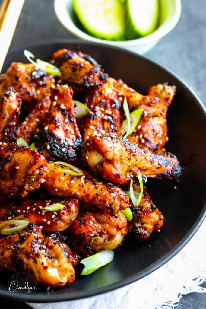 spicy asian style chicken wings or Korean BBQ wings in black bowl 