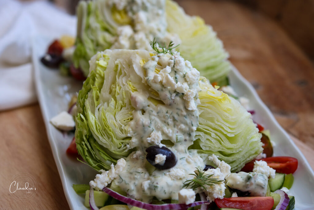 wedge salad with toppings on white plate with napkin 