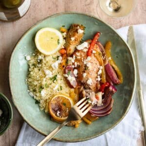 square image of artichoke chicken on green plate with couscous