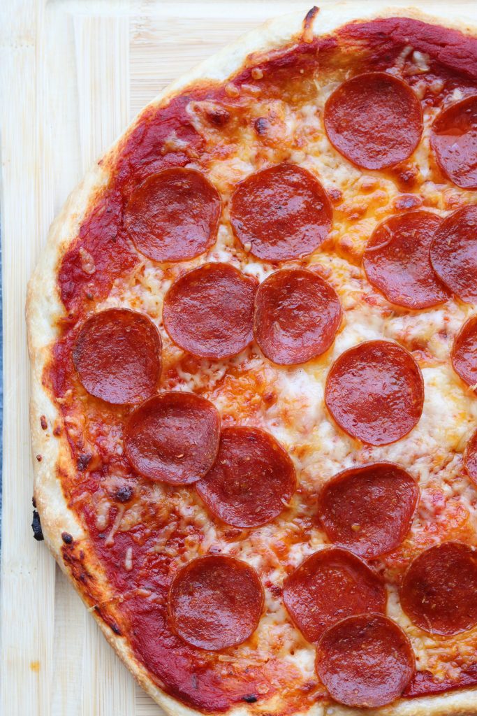 homemade pepperoni pizza on chopping block
