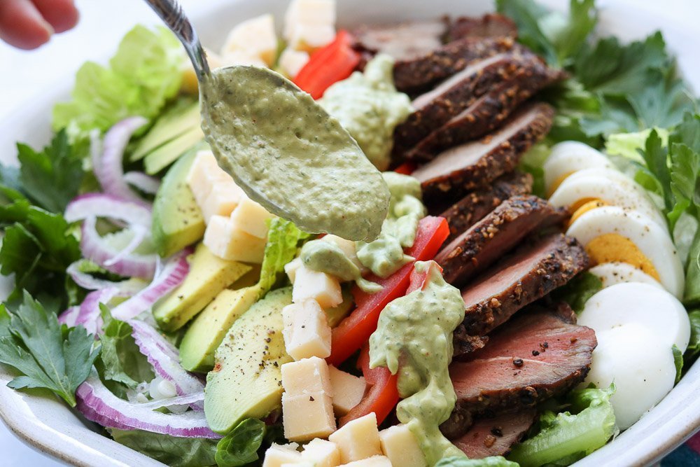 rich and spicy avocado dressing on steak salad