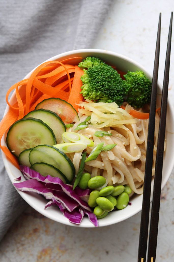 creamy sesame rice noodles in bowl with chopsticks