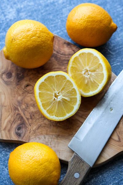 lemons on cutting board with knife and cut in half