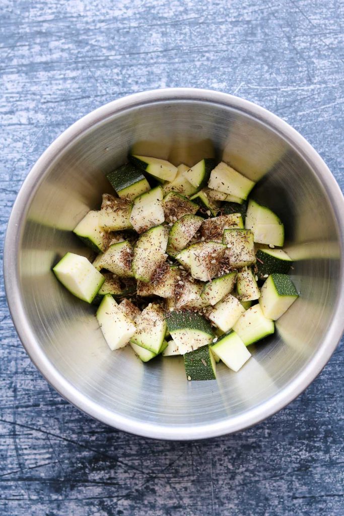 raw zucchini with olive oil and Za'atar seasoning in bowl