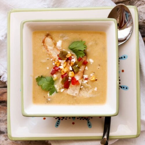 creamy potato hatch chile soup in square bowl with spoon and napkin