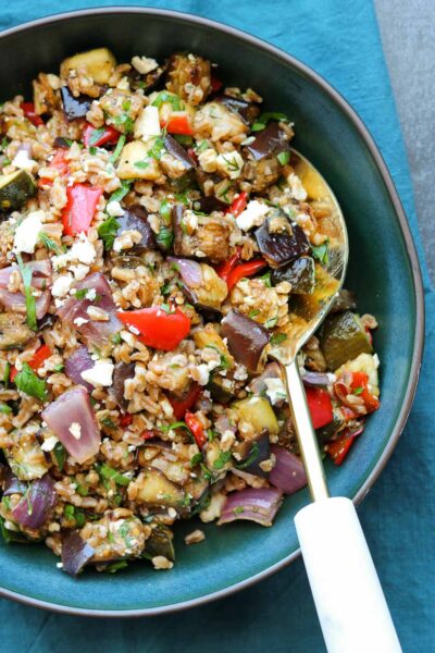 balsamic roasted vegetable grain salad with serving spoon