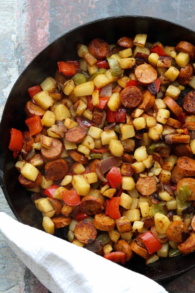 cajun spiced potato hash with sausage in skillet 