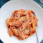 tomato butter pasta sauce in white bowl with fork