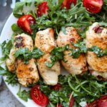 square image of chicken involtini on platter with arugula salad