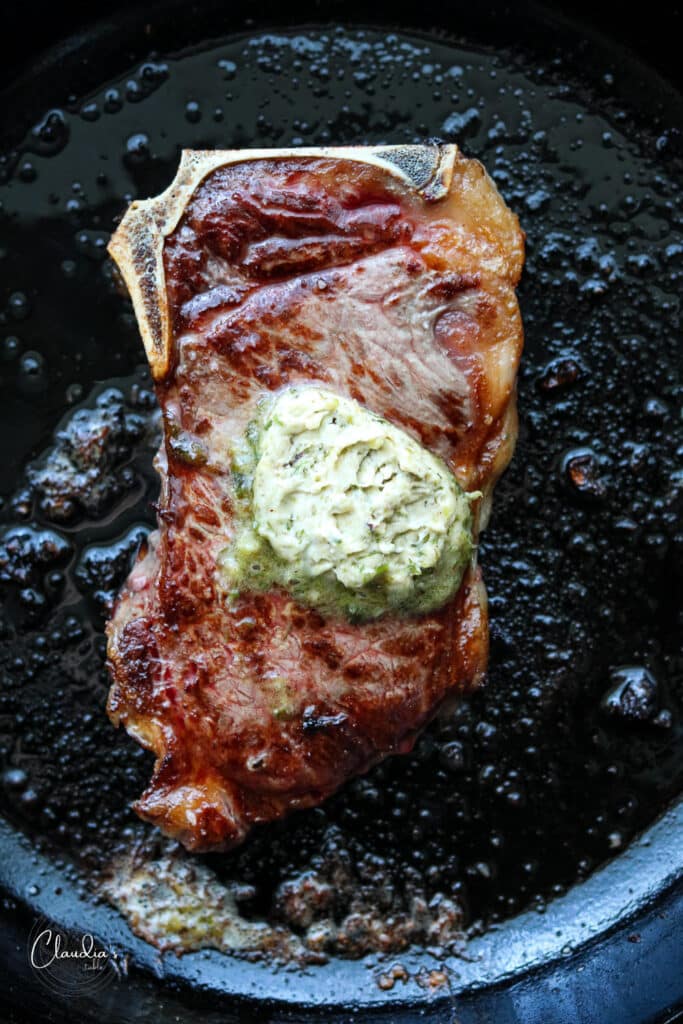 charred scallion butter on steak in cast iron skillet
