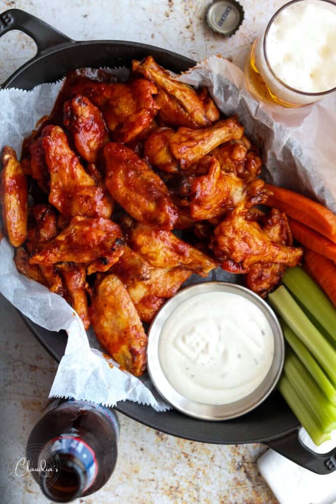 baked chicken wings with ranch dressing and bottles of beer