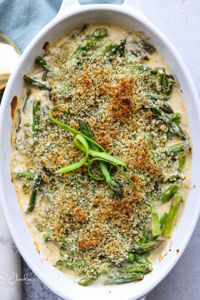 baked asparagus with gruyere in white baking dish 