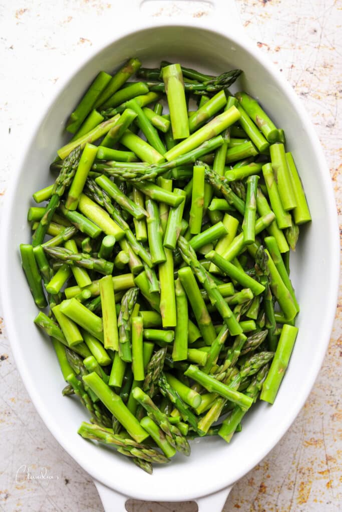 blanched asparagus pieces in casserole dish