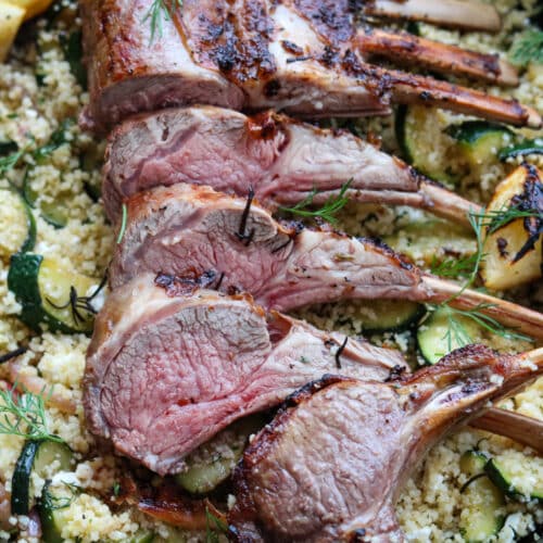 horizontal image of rosemary lemon rack of lamb with couscous with roasted zucchini