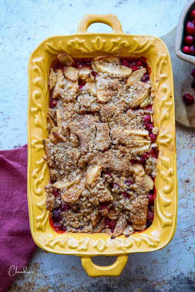apple cranberry crumble in yellow baking dish 
