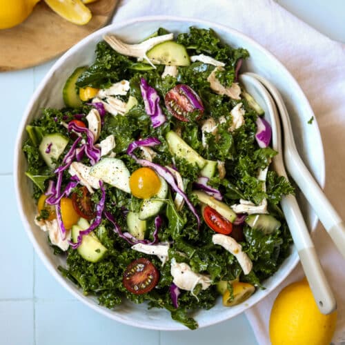 Mediterranean kale salad on white background with lemons