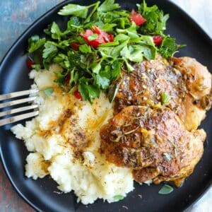 close up chicken thighs and feta mashed potatoes with parsley salad