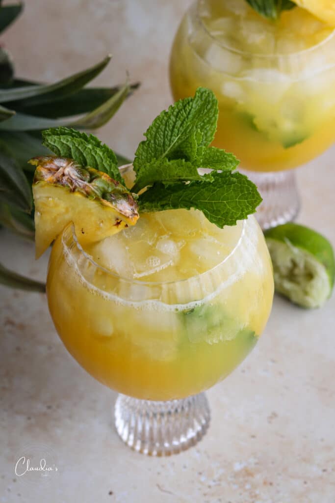 healthy tropical mocktail with fresh mint and pineapple wedge 