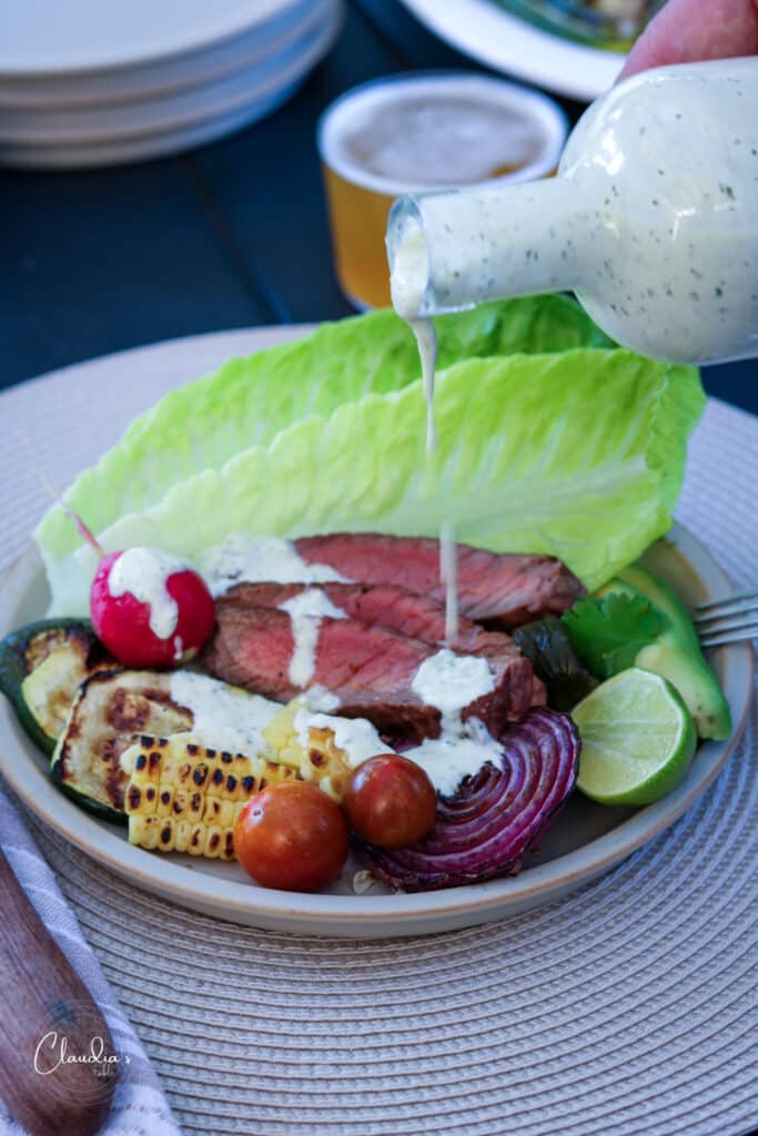 plate with grilled steak, romaine and vegetables