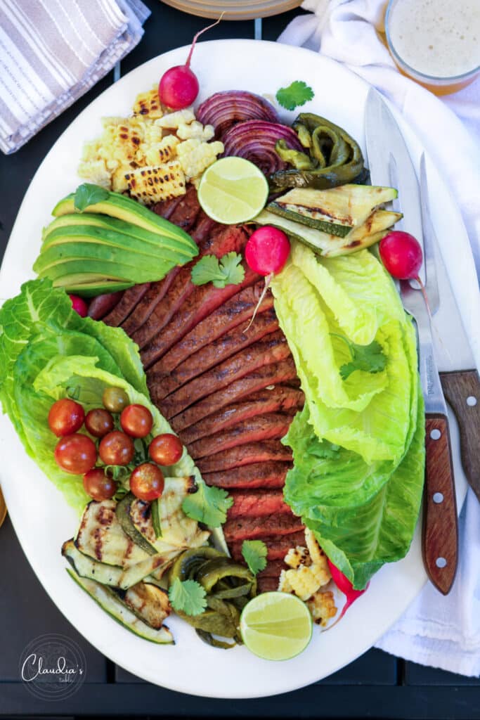 grilled steak salad with jalapeño dressing on white platter