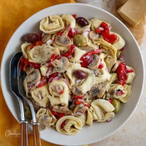 tortellini pasta salad in large bowl with yellow napkin
