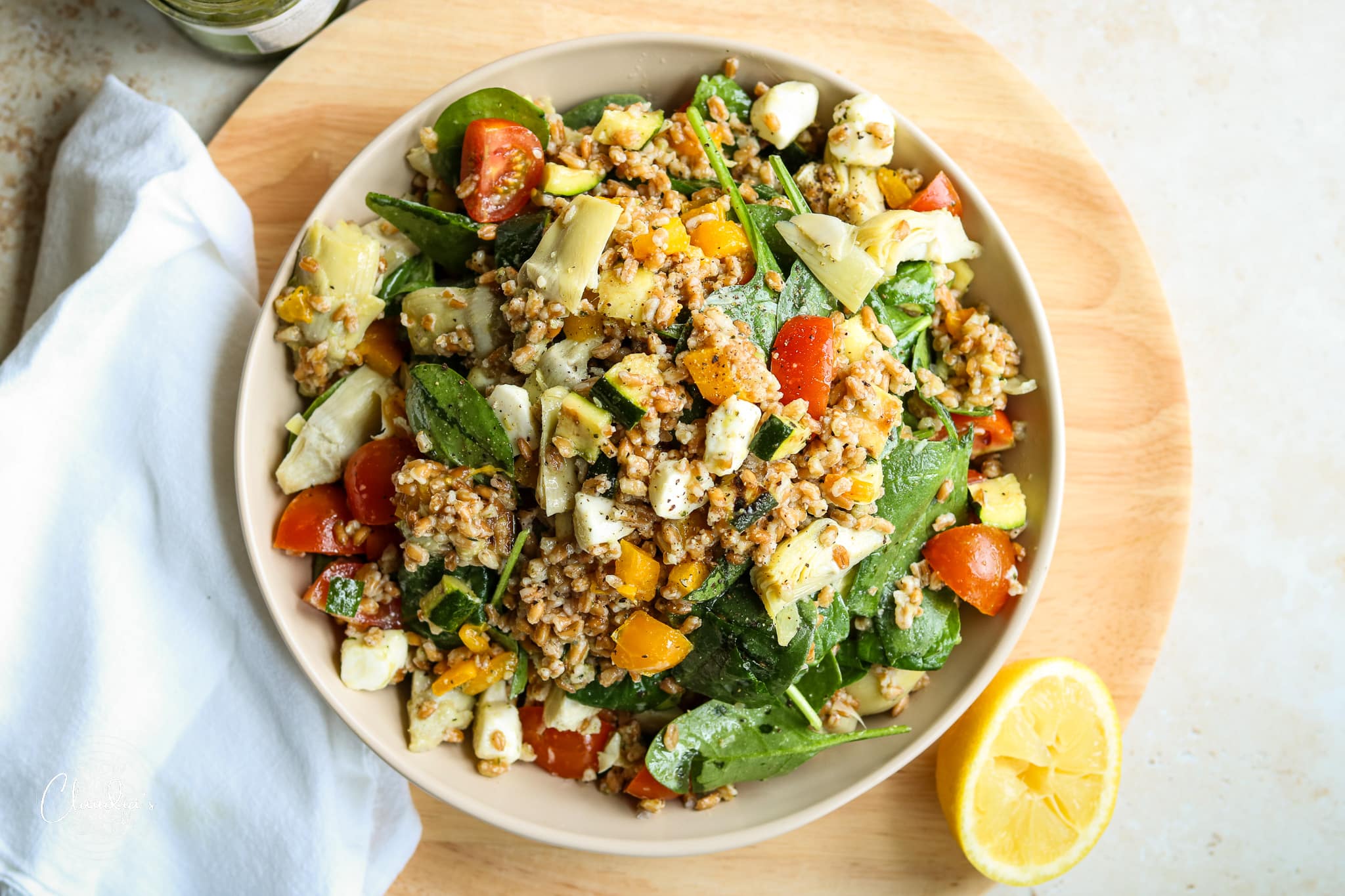 farro salad on beige bowl with lots of vegetables