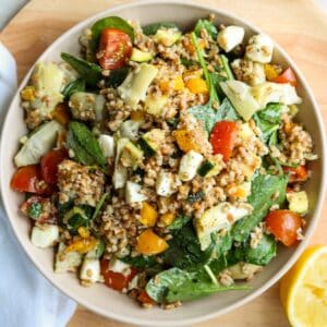 close up of farro salad in bowl with lemon