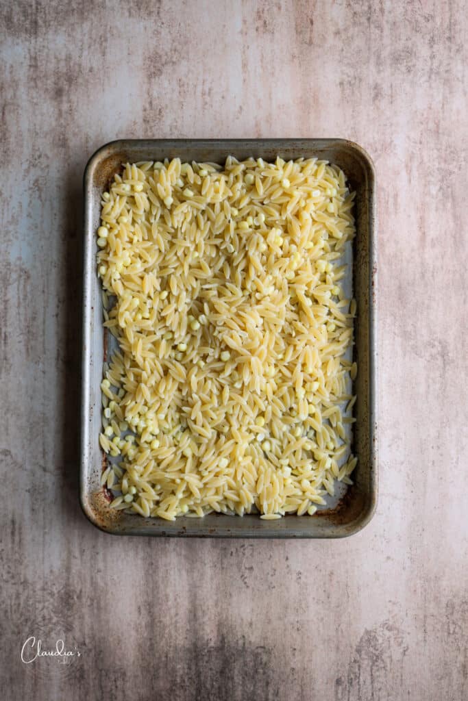 cooling the orzo on a rimmed baking sheet 