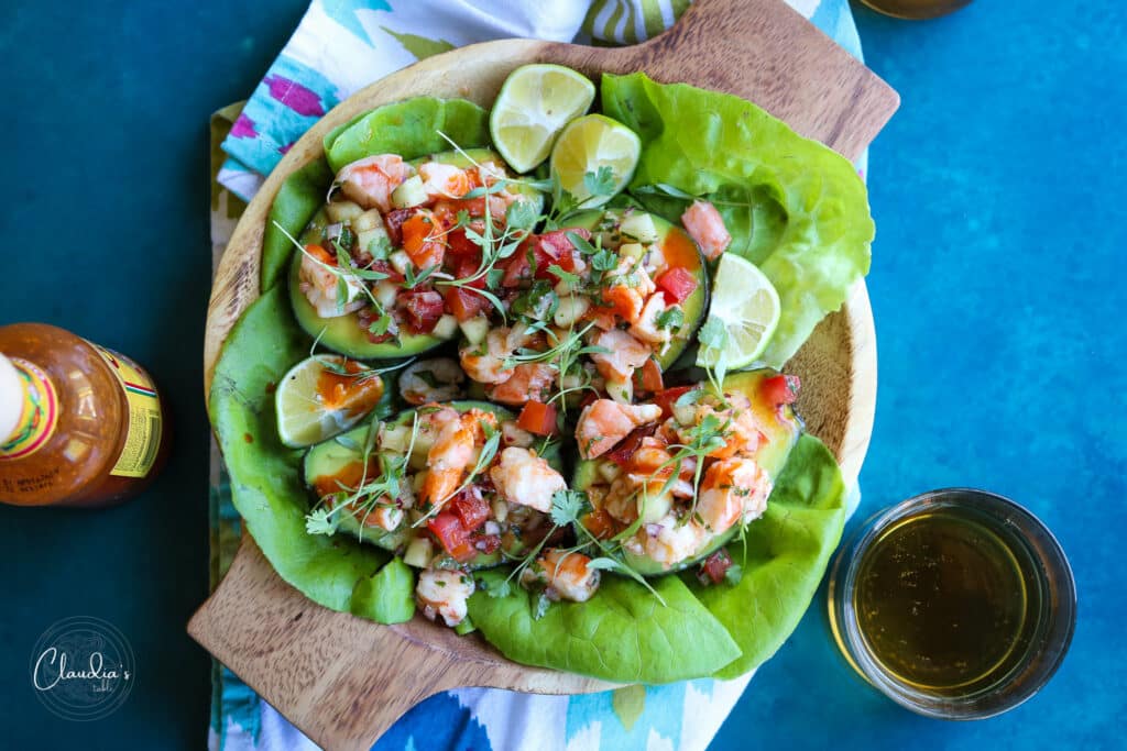 Shrimp salad served in halved avocadoes, butter lettuce, lime wedges and hot sauce.