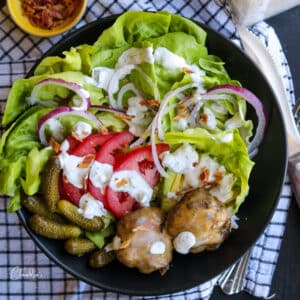 simple cheeseburger salad wtih bacon in black bowl