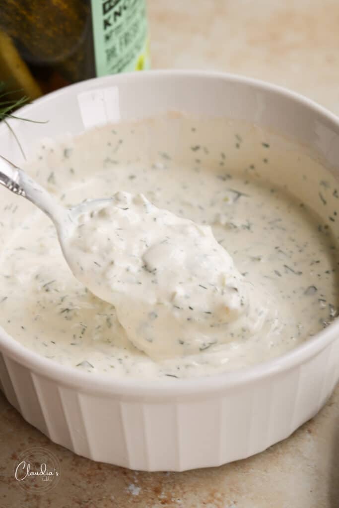 spicy dill pickle ranch dressing in white bowl with spoon