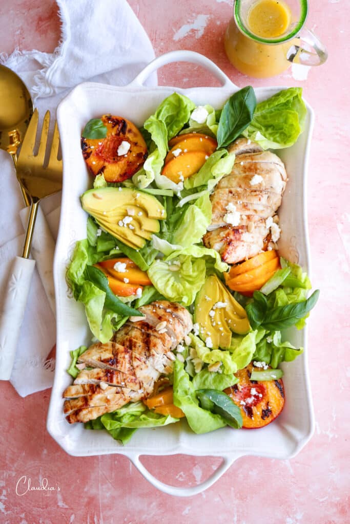 grilled peach avocado chicken salad on white platter
