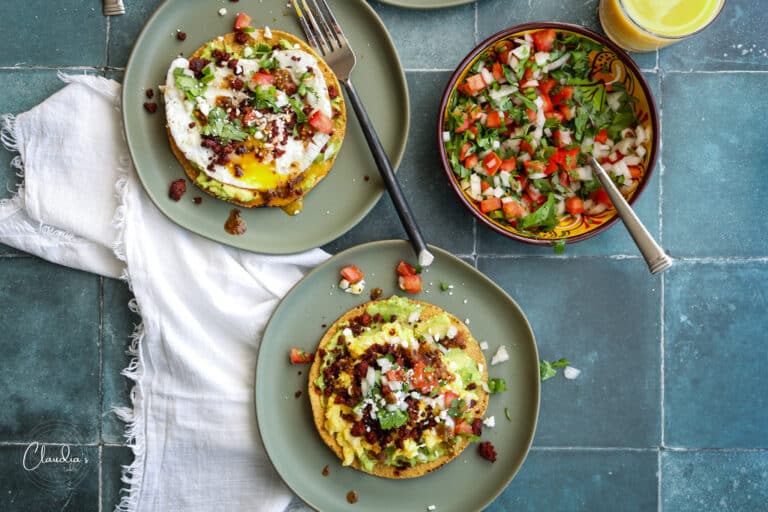 breakfast tostadas with scrambled or eggs over easy on green plates with pico de gallo